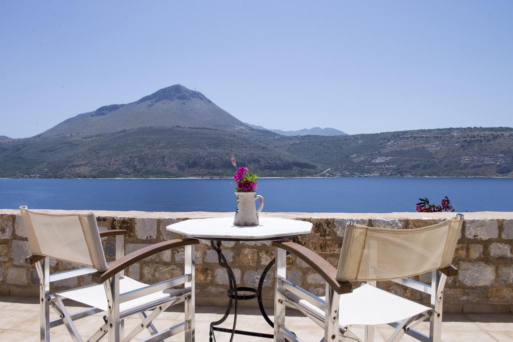 Table and chairs on a studio terrace above the bay